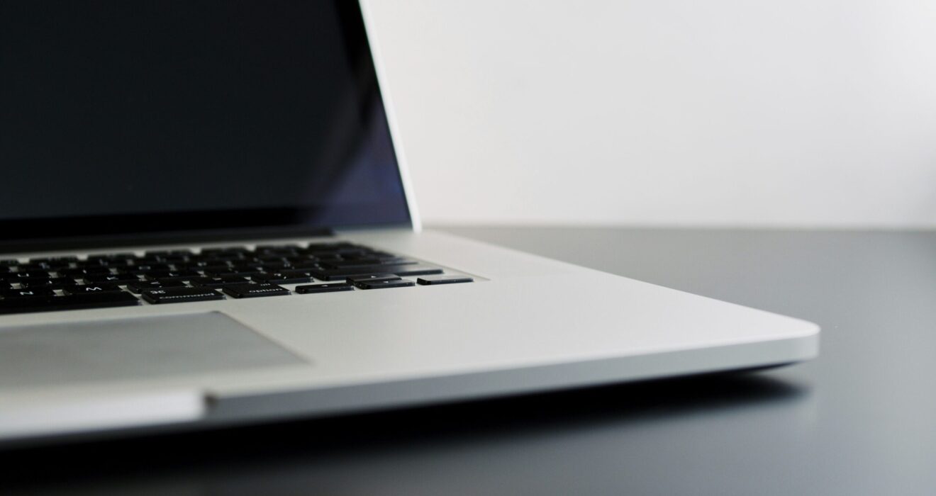 silver laptop computer on black table
