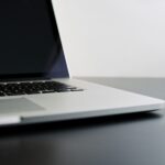 silver laptop computer on black table