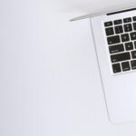 Free Aerial view of a sleek laptop keyboard on a clean, white surface, ideal for tech backgrounds. Stock Photo