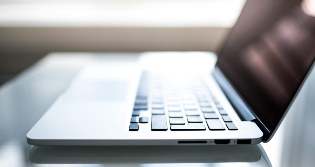 Free Elegant side view of a laptop on a glossy table with natural lighting indoors. Stock Photo